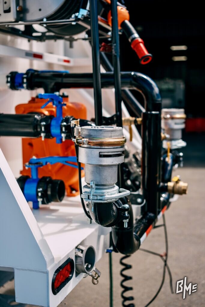 Spray valve mounted on the side of a water truck body with control plumbing