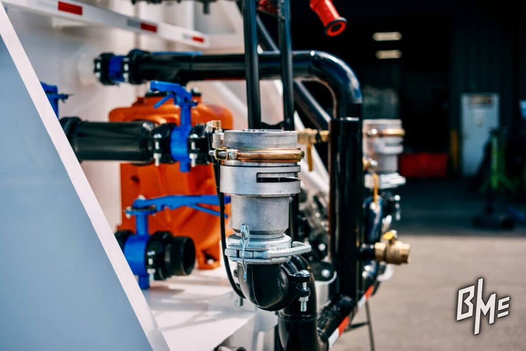 Row of spray valves and plumbing along a truck body