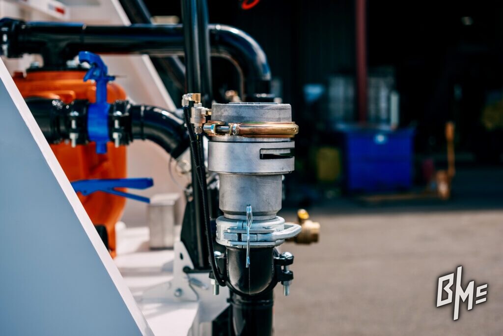 Spray valve and control plumbing against the body of a white water truck